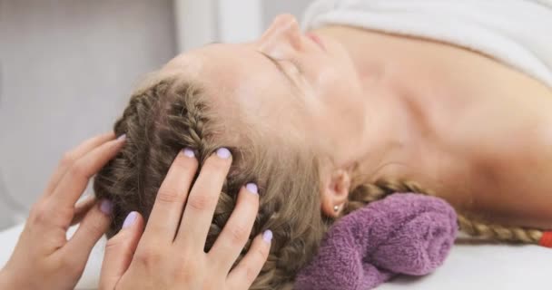 Ung kvinna som får avslappnande huvudmassage på spa-centret. Masseuse gör huvudmassage på wellness center. — Stockvideo