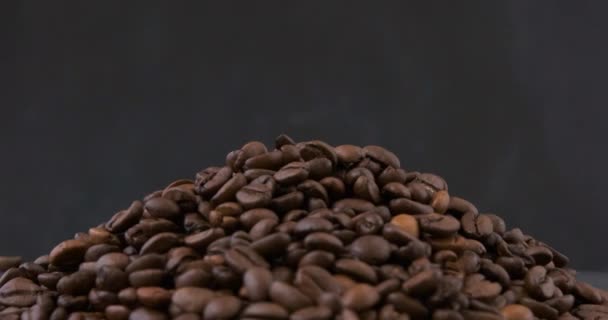 Grãos de café arábica torrados, pilha de café. Grãos de café escuros. Vista superior. Vídeo rotativo. Movimento do laço. — Vídeo de Stock
