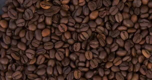 Färska rostade arabica kaffebönor närbild. Mörka kaffekorn. Högst upp. Roterande video. Rörelse i loopen. — Stockvideo
