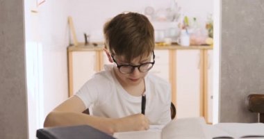 Gözlüklü çocuk ödevini yapıyor. Mesafe öğrenme. Çocuklar uzaktan eğitim.