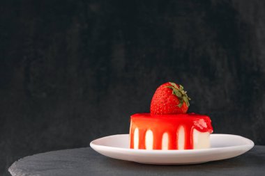 Siyah arka planda taze çilekli lezzetli meyveli pasta. Yan görüş. İştah açıcı çilekli pasta