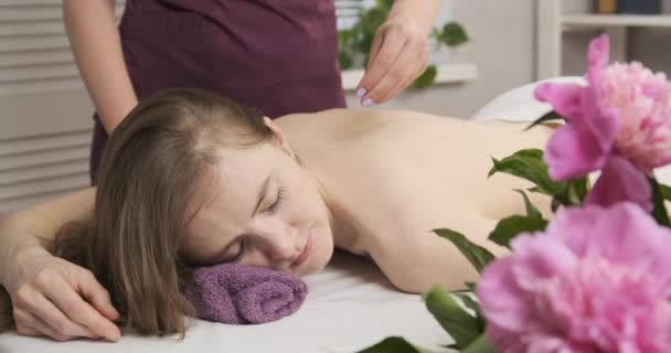 Jonge mooie vrouw ligt op een kuuroord en krijgt de rugmassage. Schoonheidsbehandelingen. Lichaamsverzorging. Ontspannende massage. — Stockvideo