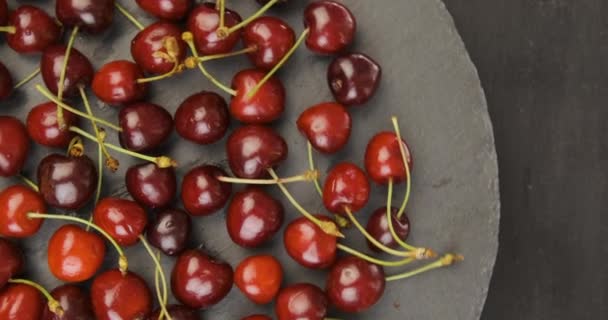 Ripe red cherries on round grey background. Top view. Rotating turntable clockwise shot. Rotating video. — Video Stock