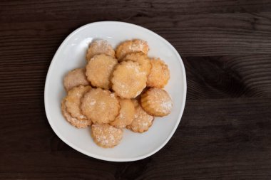 Tahta masada ev yapımı kurabiyeli beyaz tabak. Üst Manzara. Çay için pişiriyorum..