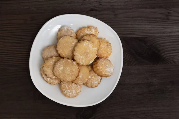 Tahta masada ev yapımı kurabiyeli beyaz tabak. Üst Manzara. Çay için pişiriyorum..