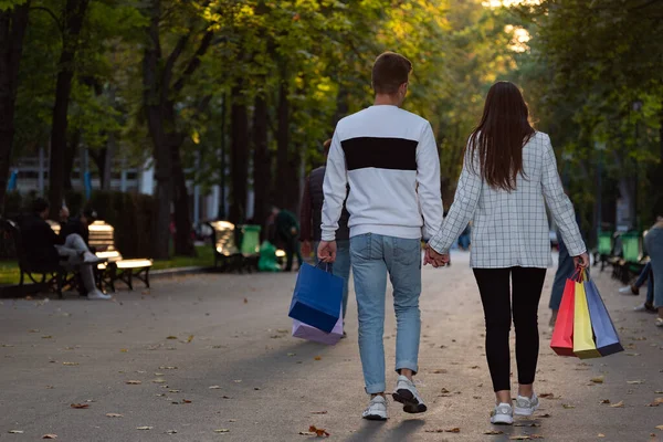 Ett Par Förälskade Promenader Parken Med Shoppingväskor Bakifrån — Stockfoto