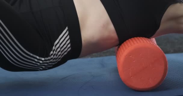 Kvinna i gymmet gör en myofascial massage av ryggen och skulderbladen med hjälp av en rulle. Fitness tränare är engagerad i fysioterapi med skumroller — Stockvideo