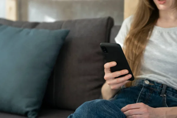 Chica Está Sosteniendo Teléfono Mientras Está Sentado Sofá Sala Estar —  Fotos de Stock