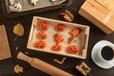 Cadılar Bayramı için zencefilli kurabiyeler masada ahşap bir formda yatar. Balkabağı şeklinde. Bir fincan kahveyle yemek çok lezzetli.
