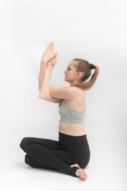 Gomukhasana. İnek Yüzlü Poz. İnce ve esnek genç kadın yoga yapıyor. Hatha yogası. Yan görünüm.