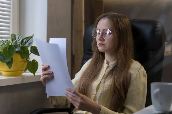 Молодая Женщина Очках Сидит Офисе Читает Рабочий Отчет Соглашение Контракт — стоковое фото