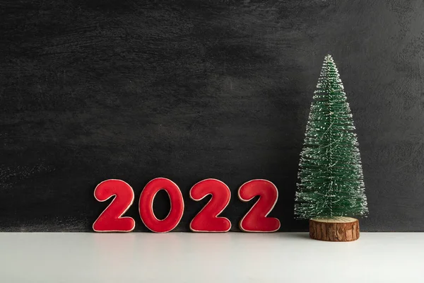 ブラックを背景にした人工的なクリスマスツリーと赤の数字2022 新年のコンセプト スペースのコピー — ストック写真