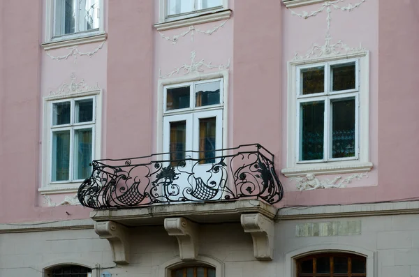 Vintage open wrought-iron balconies on a background of moldings window — Stock Photo, Image