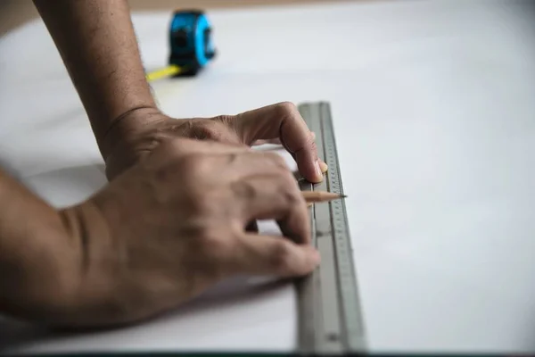 Man using measure hand tool doing wallpaper cutting work in home construction site, people with hand tool object concept