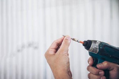 Adam elektrikli tornavida kullanarak mobilya montajı ile çalışıyor - mekanda el aletleri konseptini kullanarak teknisyen işi