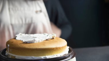 Pasta yapan kadın spatula kullanarak krema yapıyor - ev yapımı fırın pişirme konsepti