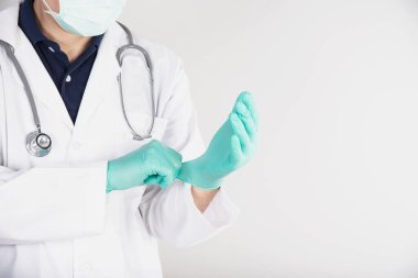 Doktor kendini korumak için yeşil ameliyat eldiveni takıyor. Tıbbi operasyon sürecine. Covid-19 'un yayılma süresi boyunca sağlık hizmeti.