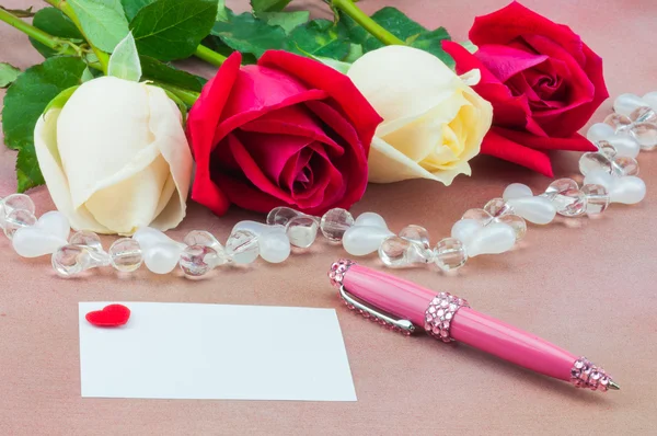 Red and white roses with small heart on card and pen — Stock Photo, Image