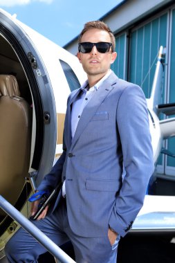 Takım elbise ayakta executive jet kapı genç adam
