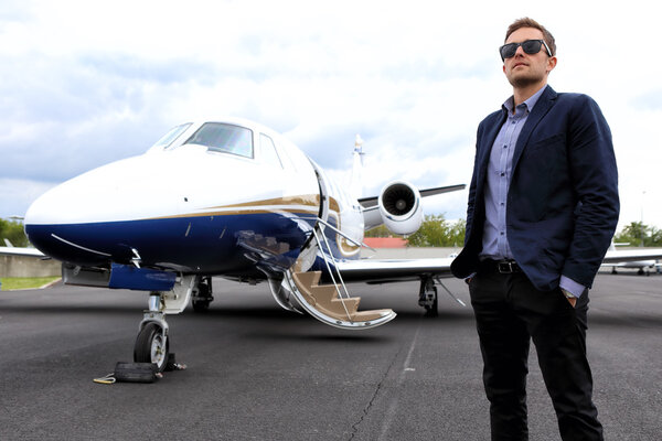 Young man in front of business jet