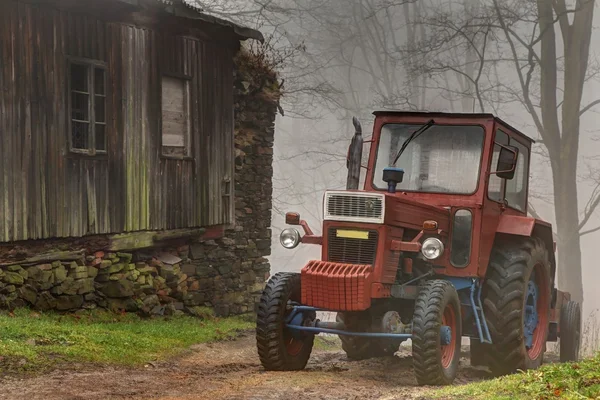 Tracteur rouge près du bâtiment en bois — Photo