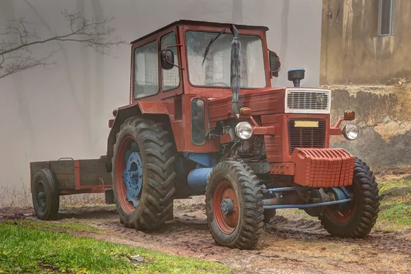 Vieux tracteur rouge avec roues bleues — Photo