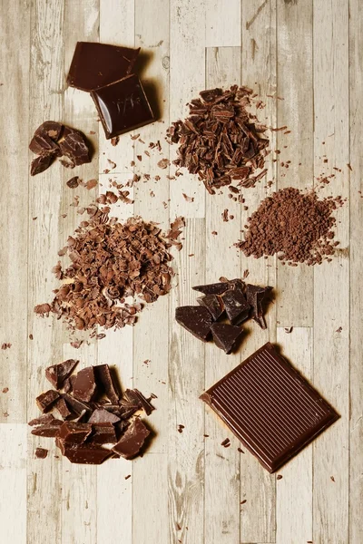 Schokoladenstücke auf dem Holzboden — Stockfoto