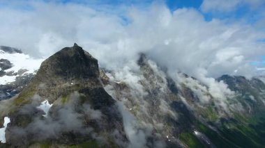 Dağ zirveleri bulutlarla, gökyüzüyle, dağıyla, buharla, karla kaplıdır.