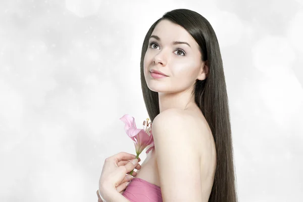 Piękna młoda kobieta brunetka z lilly różowy — Zdjęcie stockowe