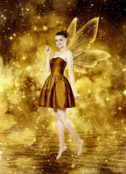 Beautiful young brunette woman as golden fairy — Stock Photo, Image