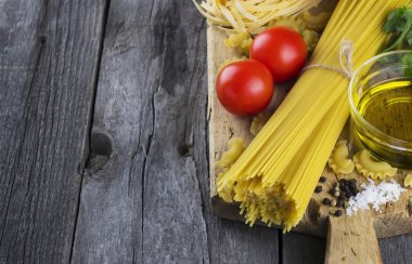Makarna, domates, fesleğen, zeytinyağı koyu ahşap arka plan üzerinde