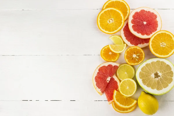 Beyaz ahşap zemin üzerinde çeşitli narenciye