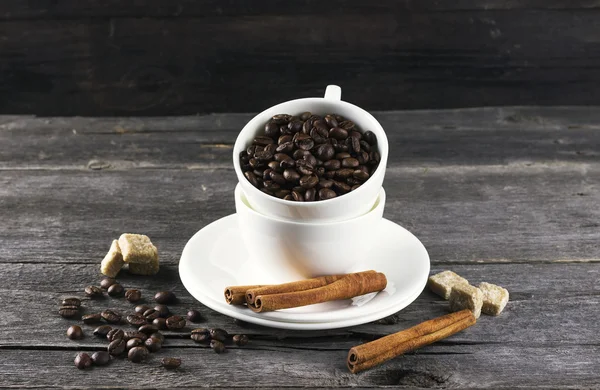 Koffie granen, suiker, kaneel op donkere houten achtergrond — Stockfoto