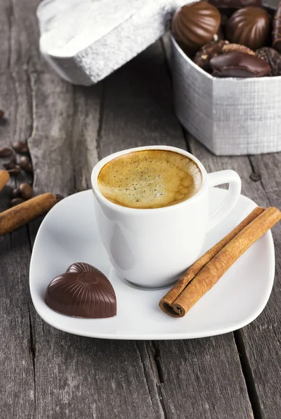 Caixa de chocolates, xícara de café em um fundo de madeira — Fotografia de Stock