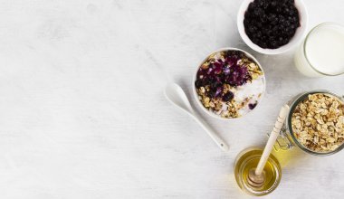 Kahvaltı: granola, yoğurt, bal, Böğürtlenli beyaz bir backgrou üzerinde