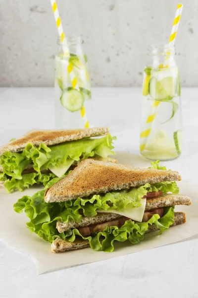 Sandwich with lettuce, cheese, tomato and lemonade on a white ba — Stock Photo, Image