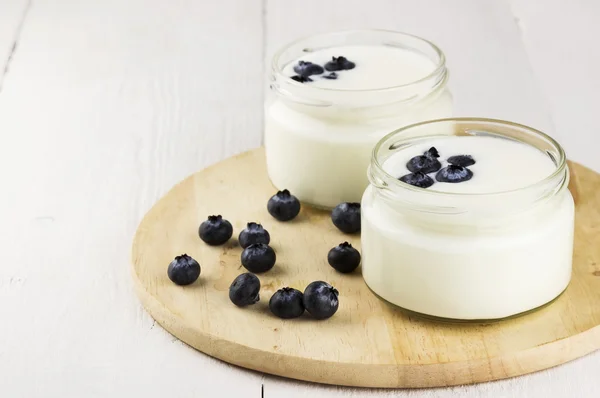Yoghurt med blåbär på vit bakgrund — Stockfoto