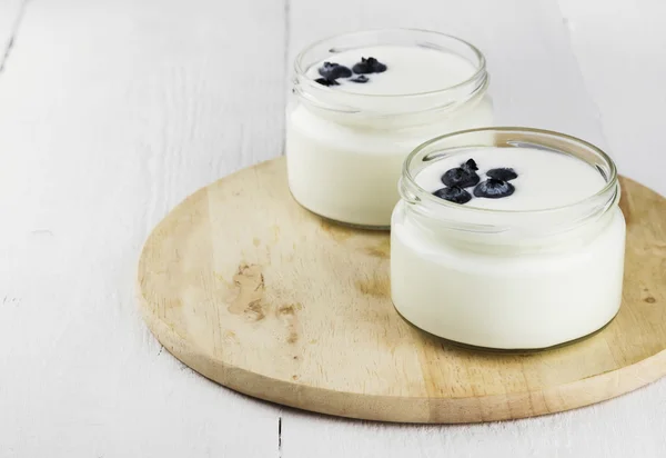 Yoghurt med blåbär på vit bakgrund — Stockfoto