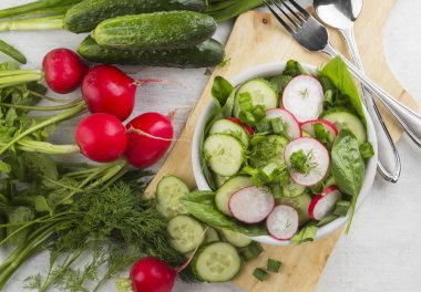 Ispanak, salatalık, beyaz bir arka plan üzerinde bir kasede turp salatası. Üstten Görünüm