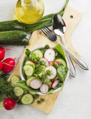 Ispanak, salatalık, beyaz bir arka plan üzerinde bir kasede turp salatası. Üstten Görünüm