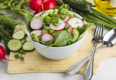 Ispanak, salatalık, beyaz bir backgr üzerinde bir kasede turp salatası