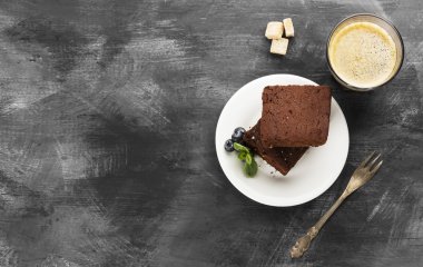 Kek parçaları ve kahve koyu arka plan üzerinde