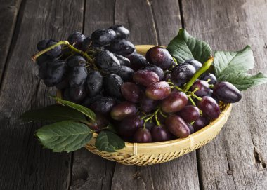 Ahşap arka plan üzerinde koyu üzüm gerdanlı kase kümeleri