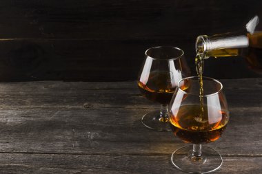 Koyu ahşap arka plan üzerinde iki bardak konyak