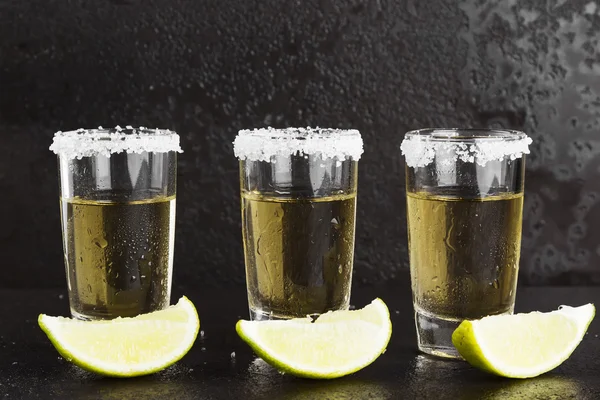 Tequila mit Salz und Limette auf dunklem Hintergrund — Stockfoto