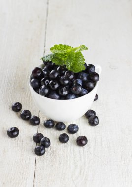 Yaban mersini ahşap arka plan üzerinde beyaz kase