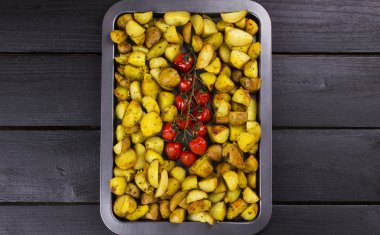 Fried potato and the baked cherry tomatoes on branch on baking s