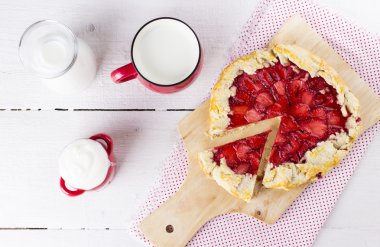 Çilek ve süt beyaz ahşap zemin üzerinde Galette'ye dilimle