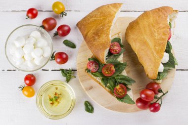 Kiraz domates, fesleğen, mozzarella ve beyaz arka plan üzerinde ciabatta sandviçle. Üstten Görünüm