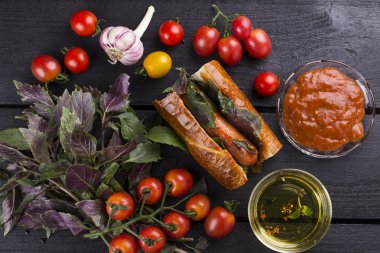 Sosisli sandviç için malzemeler: domates, sarımsak, fesleğen, ketçap
